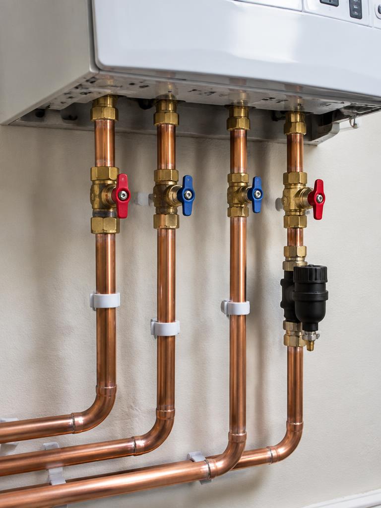 Neat copper pipework under a boiler